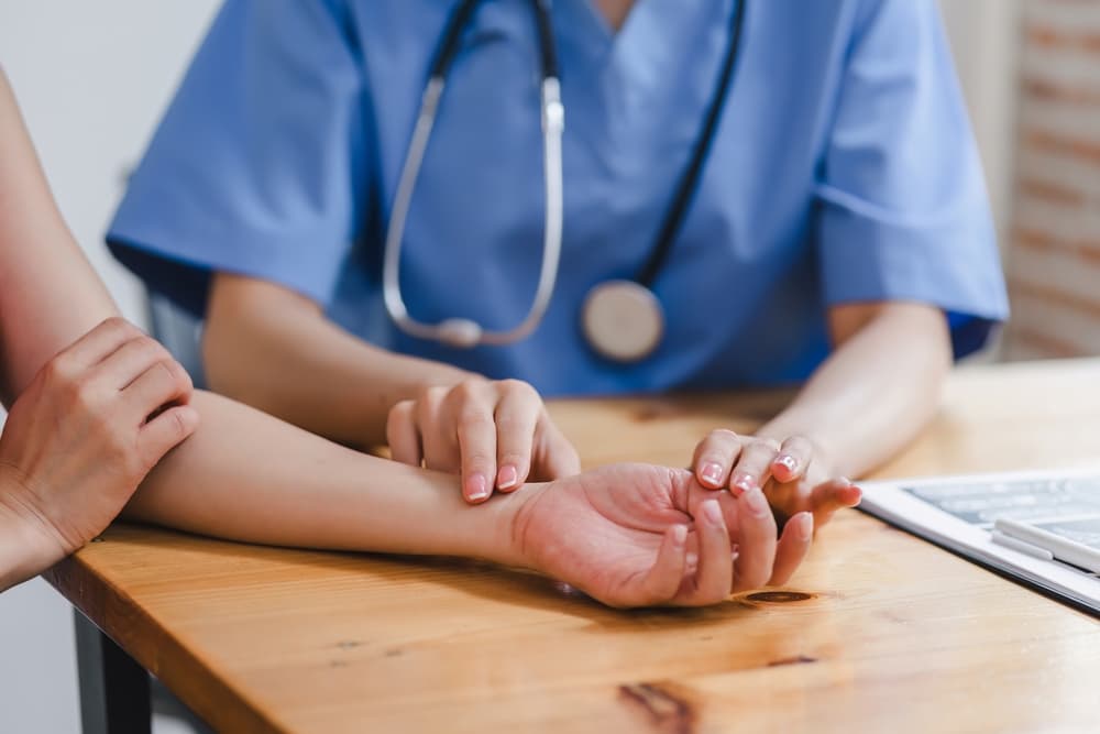 Healthcare professional taking a patient's pulse, emphasizing personal care and attention in a medical room