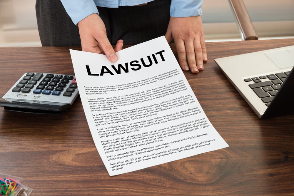 Close-up of a Lawyer Presenting a Document Labeled "Lawsuit".