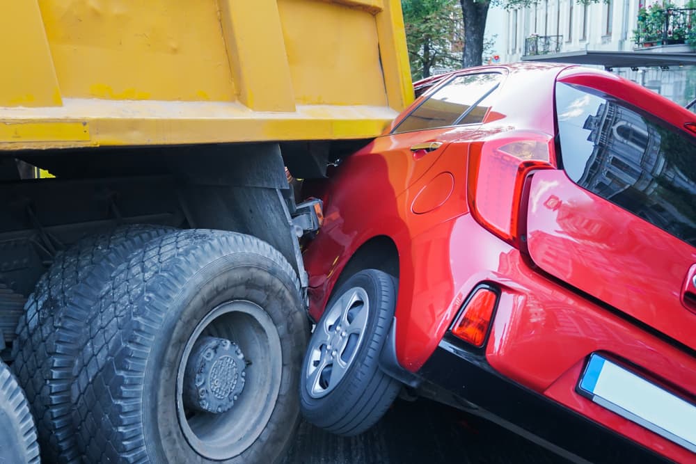 Collision between a truck and a car at a gas station resulting in a traffic accident.